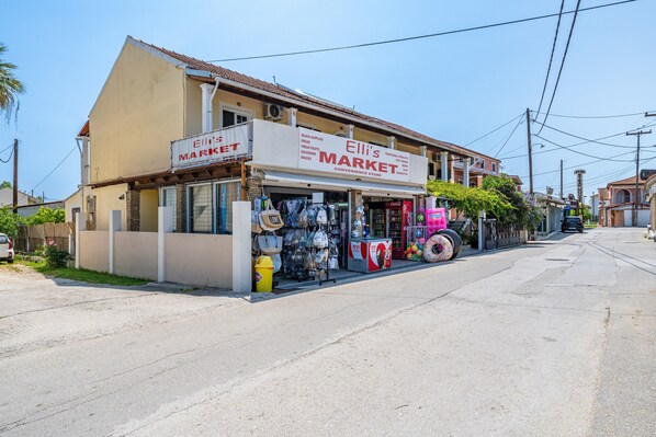 Un edificio de dos pisos con un cartel que dice 'Ellis Market' en la planta baja.