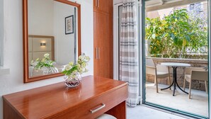 Un bagno con un mobile bagno in legno, uno specchio e un vaso con fiori.