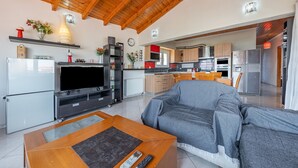 Una sala de estar moderna con un sofá, televisión y una mesa de centro de madera.