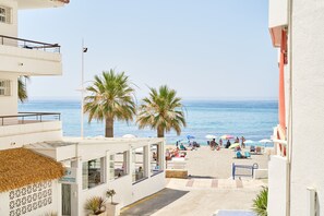 A coastal hotel with a restaurant, outdoor seating, palm trees, and a beach view. - Apartment 'Torresol 208' with Shared Pool, Wi-Fi and Air Conditioning (Nerja)