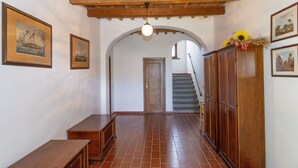 A hallway with wooden beams, a bench, a staircase, and framed pictures on the walls. - Apartment 'Casa Milla - Bilocale Becaccia' with Shared Pool, Shared Terrace and Wi-Fi (Cecina)
