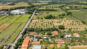 An aerial view of a residential area with houses, a swimming pool, and agricultural fields. - Apartment 'Casa Milla - Bilocale Becaccia' with Shared Pool, Shared Terrace and Wi-Fi (Cecina)