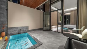 A modern indoor pool area with a stone-lined pool, glass doors leading to a living area with a sofa and a coffee table. - Songmo Hotel (Huzhou)