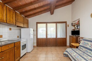 Una cocina con armarios de madera, un refrigerador blanco y una estufa.