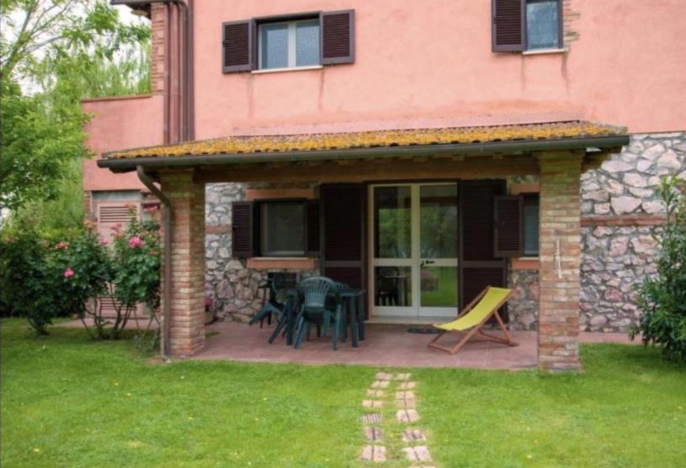 A house with a patio, outdoor seating, and a garden.