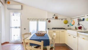 Une cuisine équipée d’une table à manger, de chaises, d’une cuisinière et d’un évier.