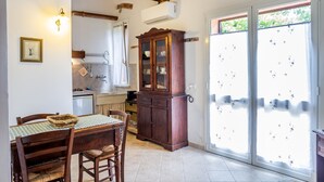 Ein Essbereich mit Holztisch, Stühlen, einem Schrank und einem Fenster mit Blick.