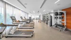 A modern gym with treadmills, weight machines, and kettlebells. - Stylish Studio | Pool View | Downtown Doral' Heart (Doral)