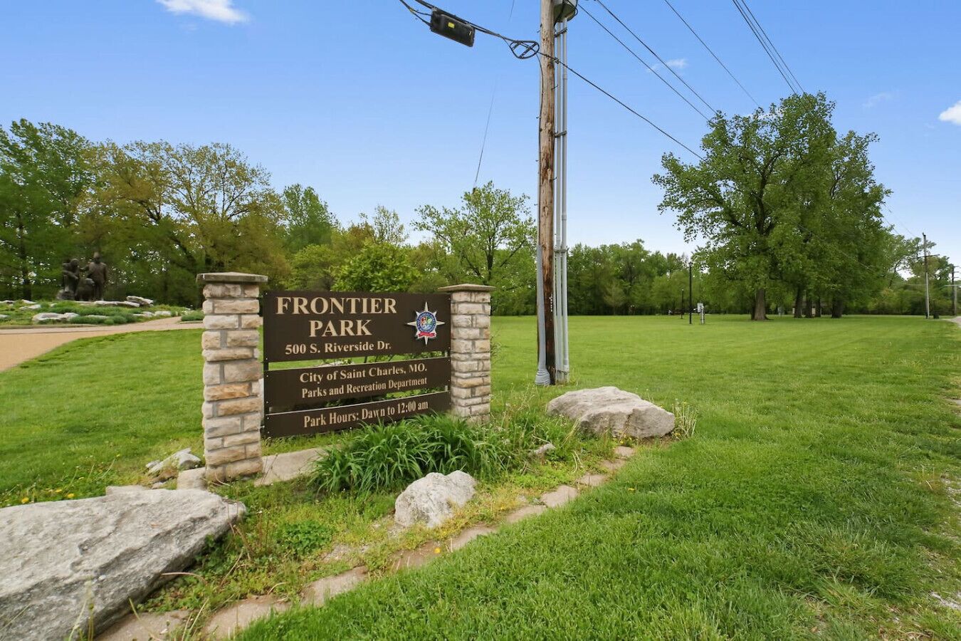 A sign for Frontier Park with a stone pillar, located at 500 S. Riverside Dr., managed by the City of Saint Charles, MO.