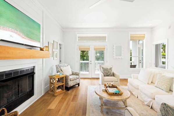 A living room with a fireplace, a television, and a large window.