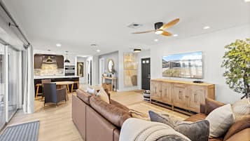 A modern living room with a sofa, a wooden cabinet, and a television.