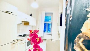 Una cucina moderna con mobili bianchi, un fornello e una finestra con tende blu.