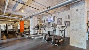 Ein Fitnessstudio mit Laufbändern, Crosstrainern und Krafttrainingsgeräten.