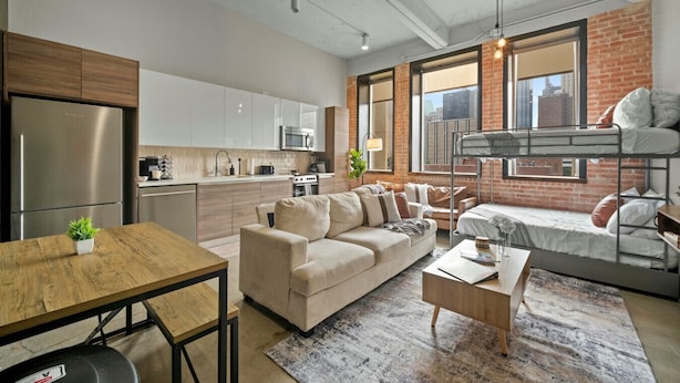 Un apartamento moderno con cocina, sala de estar y una litera.