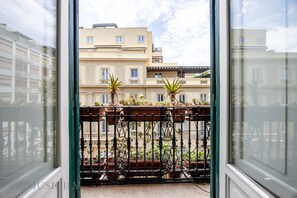 Ein Balkon mit Blumentöpfen und schmiedeeisernem Geländer.