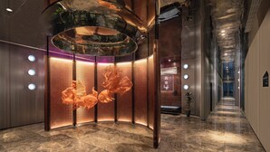 A modern interior with a curved metallic structure, a marble floor, and a long hallway with a bench and a potted plant. - lyf Xian Dayanta by Ascott (Xi'an)