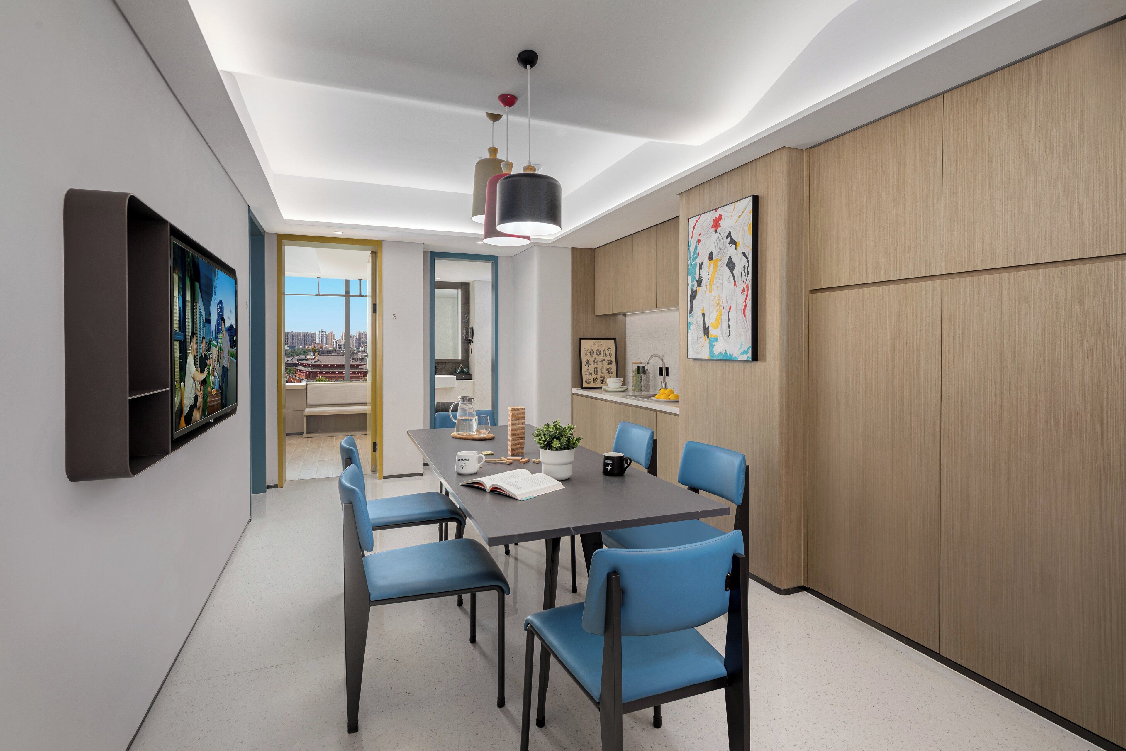 A modern dining area with a table, chairs, and a ceiling light.