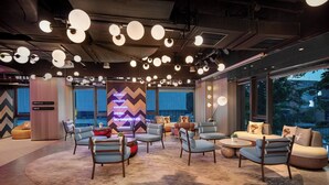 A modern lounge area with multiple seating options, including sofas and chairs, arranged around a central rug. - lyf Xian Dayanta by Ascott (Xi'an)