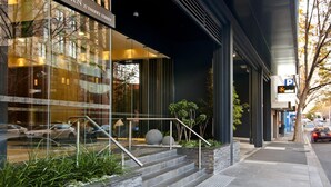 A modern building with a glass facade, a sign reading "ZEN 27 THERRY STREET," and a visible parking sign. - Nook Melbourne - Zen Apartments (Melbourne)