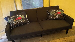 A dark brown sofa with two decorative pillows in a tent-like structure. -  1-room yurt in Seward (Seward)