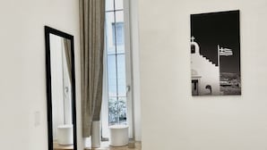 A hallway with a mirror, a window with curtains, and a framed picture of a white building with a flag. - Welcome to the vibrant heart of Moscova, where this exclusive apartment welcomes you with elegance and style, offering you a dream stay in the most dynamic and sophisticated area of Milan. ✨🏙️BEDROOMS: YOUR RELAXING RETREATThe apartment features t (Milan)