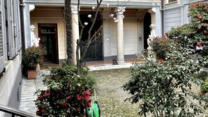 A courtyard with a building entrance, a tree, and potted plants. - Welcome to the vibrant heart of Moscova, where this exclusive apartment welcomes you with elegance and style, offering you a dream stay in the most dynamic and sophisticated area of Milan. ✨🏙️BEDROOMS: YOUR RELAXING RETREATThe apartment features t (Milan)