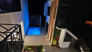 A modern outdoor area with a pool, geometric landscaping, and a staircase leading to a second level. - Casa Love Us (Tequisquiapan)