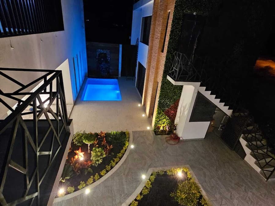 A modern outdoor area with a pool, geometric landscaping, and a staircase leading to a second level.