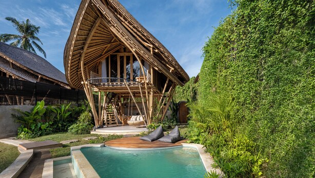 A unique, curved wooden structure with a pool in front. - Emana Bambooscape (Ubud)