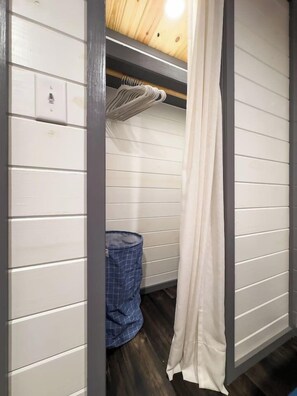 A bathroom with white walls, a wooden ceiling, a towel rack, and a blue checkered bath mat. - Rustic & Private 5 Acres- Hot Tub, Fire Pit, Grill (Canyon Lake)