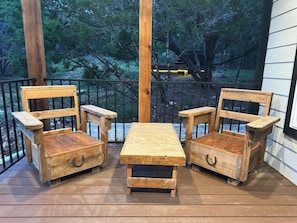 A wooden deck with a table and two chairs. - Rustic & Private 5 Acres- Hot Tub, Fire Pit, Grill (Canyon Lake)