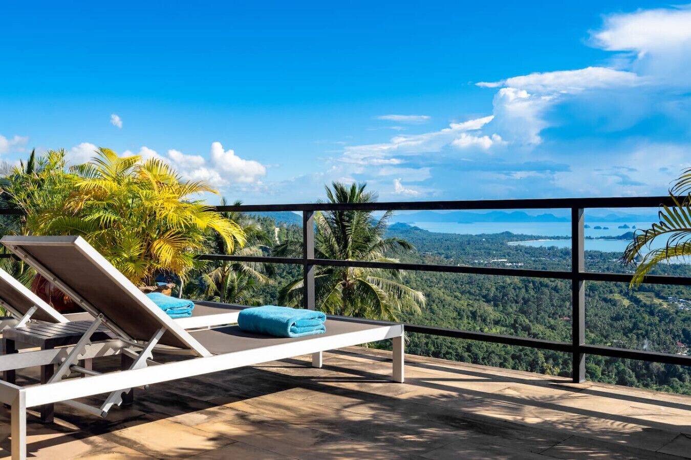 A balcony with a view of a mountainous landscape and a body of water.