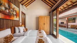 A hotel room with two beds, a wooden wardrobe, and a view of a swimming pool. - Casa Bojo & Casa Bella Uluwatu (Pecatu)