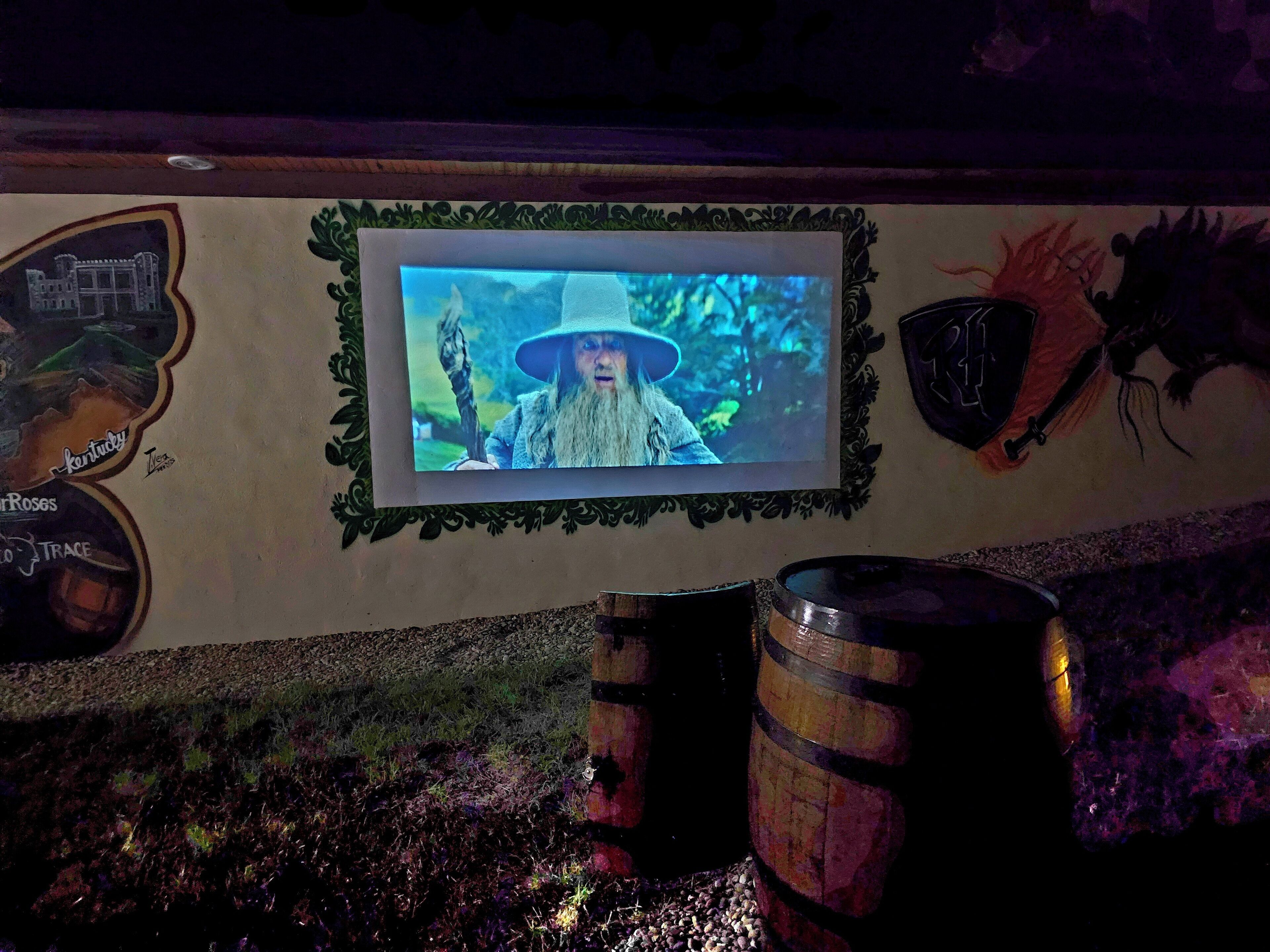 Eine Wand mit einem gerahmten Bild, einem Wappen und einem Fass.