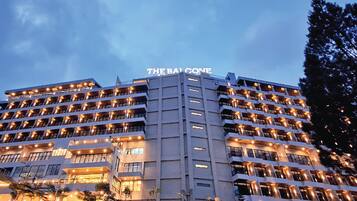 Een meerlaags hotel met balkons en een bord met de tekst 'THE BA GONE' bovenaan.