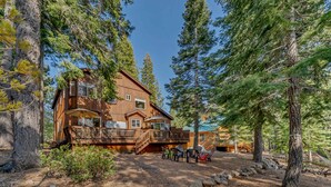 A large wooden cabin with multiple decks, surrounded by tall pine trees. - Spacious Pet-Friendly Truckee Retreat with Hot Tub (Truckee)