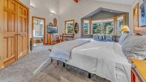 A spacious bedroom with a large bed, wooden wardrobe, and a desk area. - Spacious Pet-Friendly Truckee Retreat with Hot Tub (Truckee)