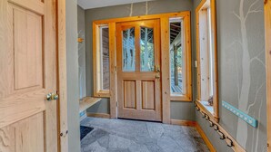 A wooden door with a glass panel, a coat rack, and a window with a view of trees. - Spacious Pet-Friendly Truckee Retreat with Hot Tub (Truckee)