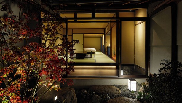A traditional Japanese-style room with tatami flooring, a low table, and a bed. - Enso Machiya (Kyoto)