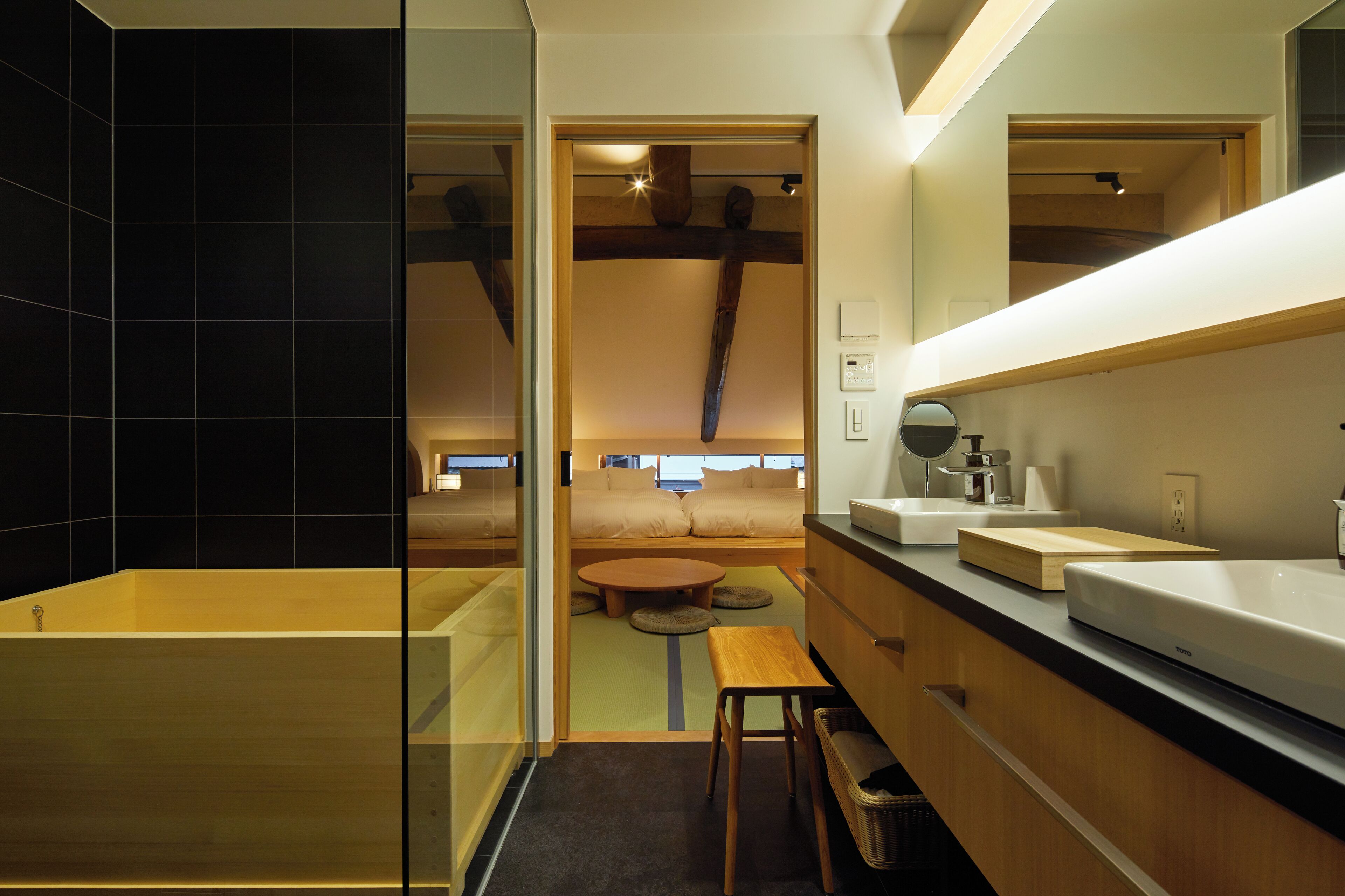 A modern bathroom with a bathtub, a wooden bench, and a round table.