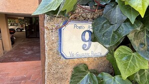 Entrada de un edificio con un cartel que dice 'Porto 9 Via Giuseppe Romita'.