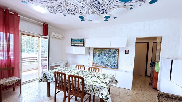 Un comedor con una mesa dispuesta para cuatro, un techo de diseño único y obras de arte en las paredes.