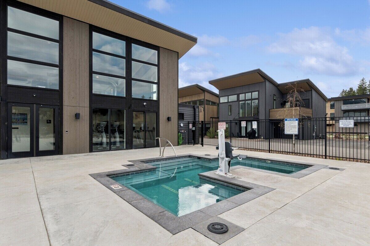 A modern building with large windows, a pool area, and a sign indicating a spa.