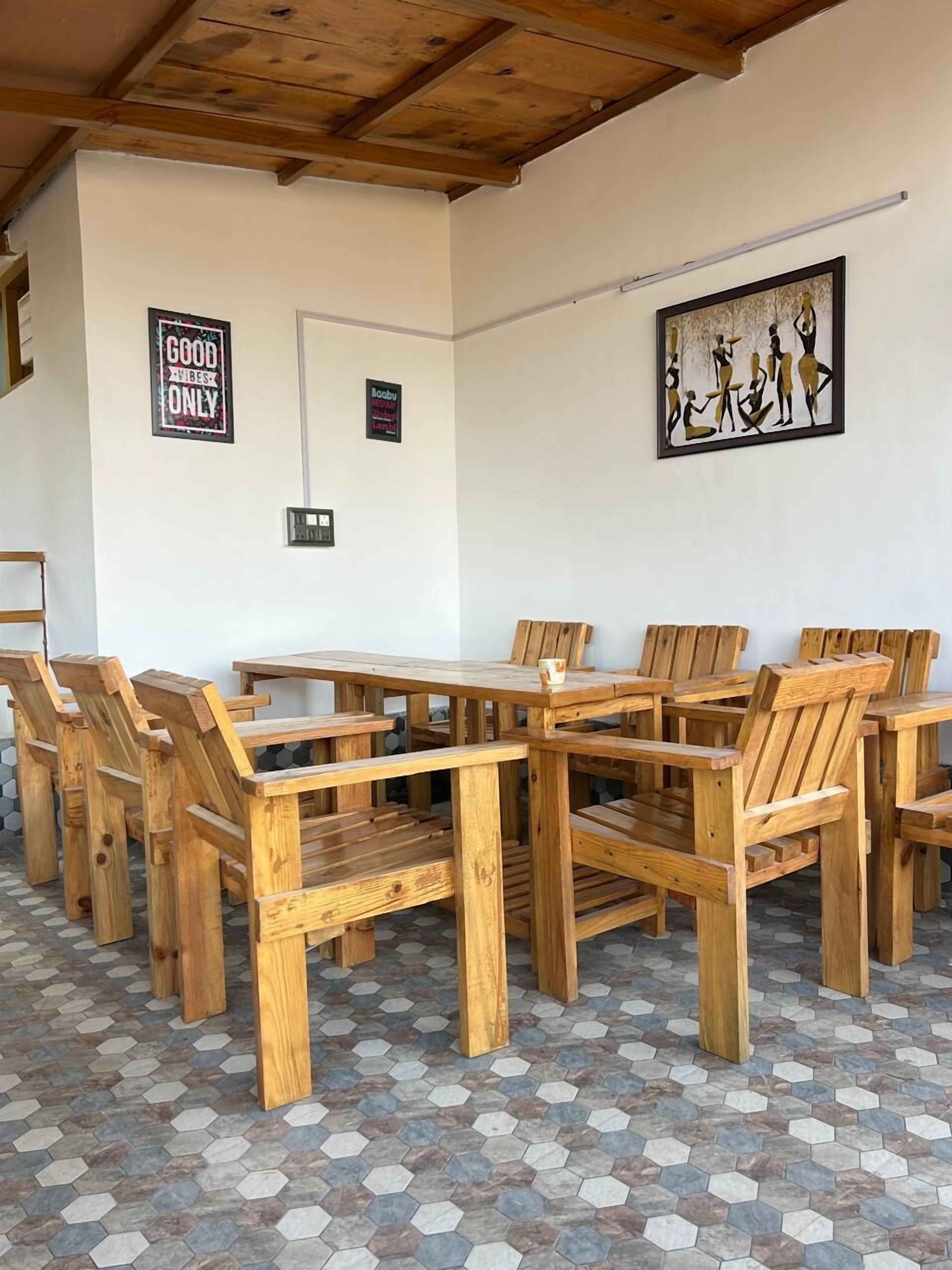 Un'area pranzo in legno con piastrelle a motivi esagonali, un soffitto in legno e un quadro appeso al muro.