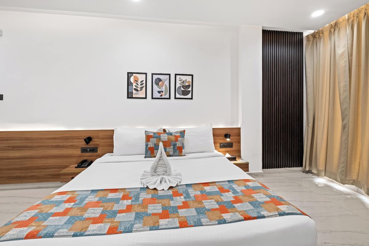 Una habitación de hotel moderna con una cama bien hecha, un colcha y tres obras de arte enmarcadas en la pared.