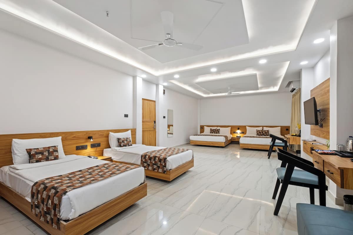 Una habitación de hotel moderna con dos camas, un escritorio, una silla y un televisor.