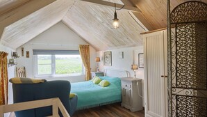 Ein gemütliches Schlafzimmer im Dachgeschoss mit Bett, Schreibtisch und Kleiderschrank.