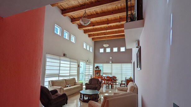 A spacious living room with a high ceiling, large windows, and a dining area. - Luxury Home with Pool, Gym & EV Charger – Prime Location in Querétaro (Santiago de Querétaro)