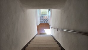 Un escalier menant à une pièce dont le sol est recouvert de carreaux décoratifs.