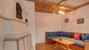 A cozy room with a wooden bench, a blue sofa with colorful cushions, and a wooden table. - Apartment 4 for 2 persons, 1 separate bedroom, balcony, 58 m² (Inzell)